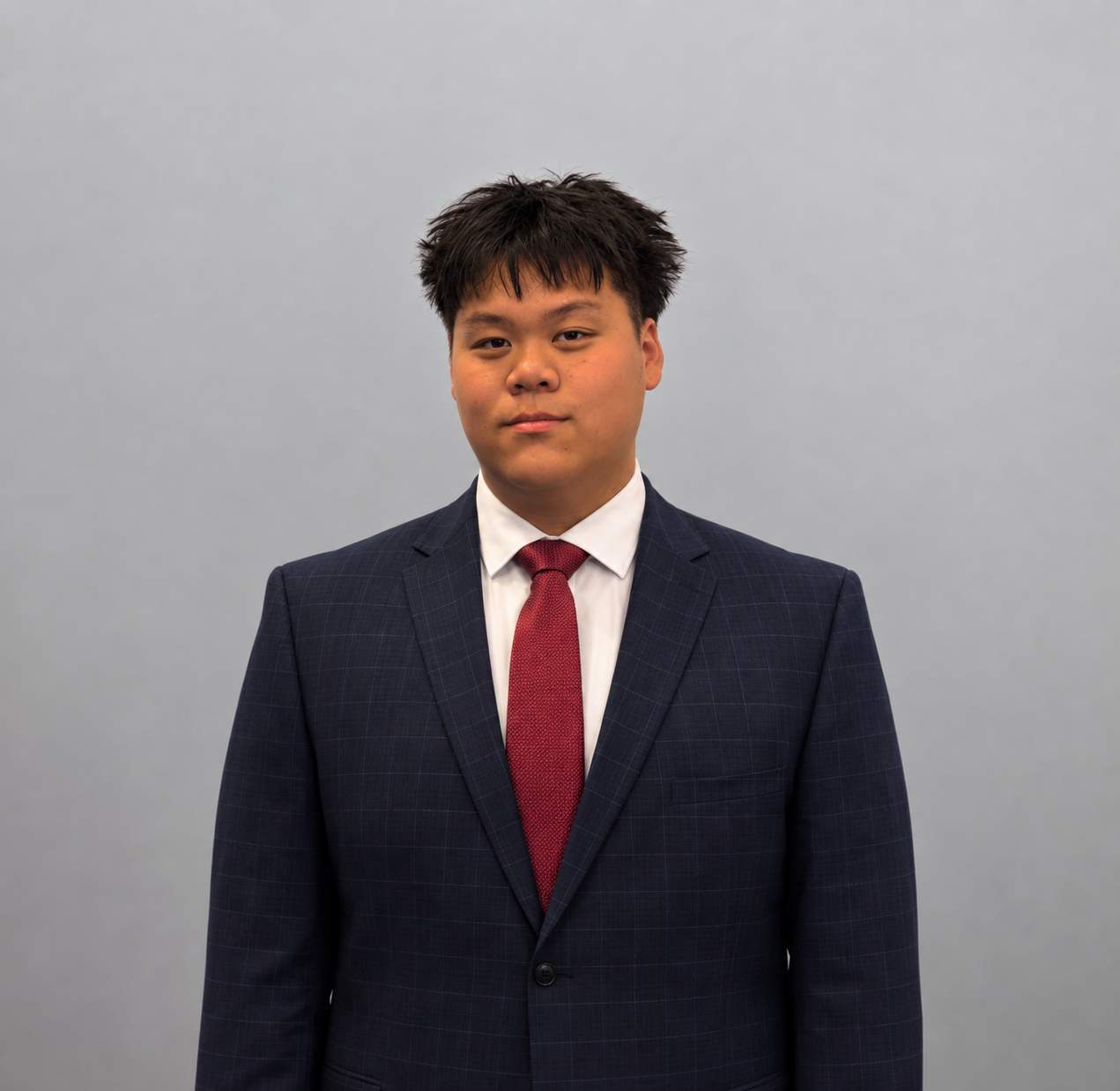 Kevin Dang, Eagles FFC coach, in a navy suit with a red tie